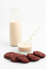 Cherry cookies and glass bottle of melted milk on white background