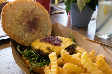 Unusual black burger with beef and crispy onion and tasty chicken nuggets with chips