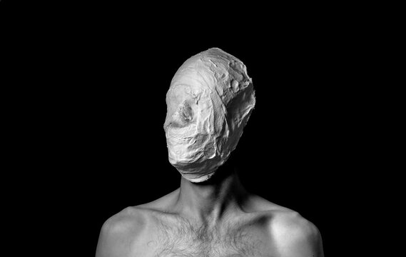 black and white photo of a man in a plaster mask