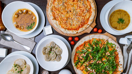 Fototapeta na wymiar Pizza with arugula and shrimp and pizza quattro formagi, dumplings and cream soups top view