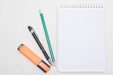 Spiral notebook, pens and marker, top view, white background, copy space
