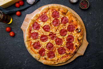 Pepperoni pizza on black concrete table top view