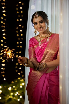 Woman smiling with a sparkler in her hand	