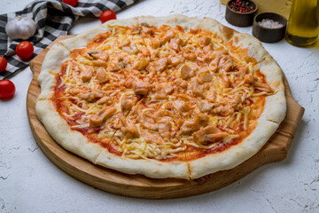 Pizza with salmon on white concrete table