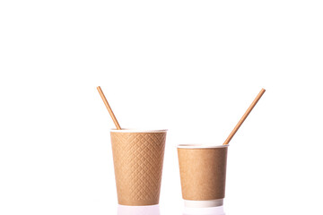 Two disposable brown paper cups small and medium sizes with straws isolated on white background. Coffee, takeaway hot drinks, Recycling, eco-friendly tableware concept, mockup template. Copy space