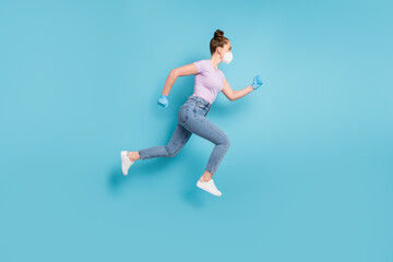 Full length profile photo of attractive lady use respirator jump up running rushing shopping center sale season addicted shopper wear t-shirt jeans shoes gloves isolated blue color background