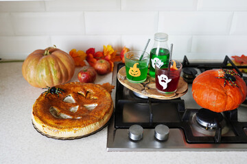 homemade pie with drinks and decorations for Halloween on light kitchen