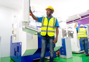 African American factory worker work with the machine in workplace area. Concept of good management system to support industrial business working.