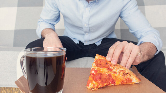Man with a slice of pepperoni pizza, male hands, cropped image, close-up, 16: 9