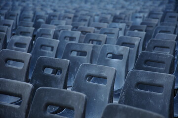Minimalist view of large number of empty chairs arranged in a rows.