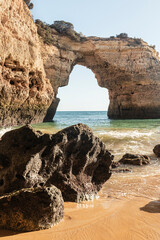 Rock arch by the beautiful sandy beach in Portugal.