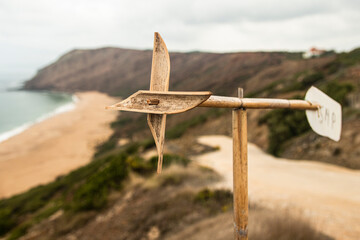 Wooden windmill above the cliff by the beach (Portugal).