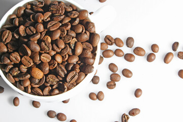 White cup full of coffee beans.Top view.