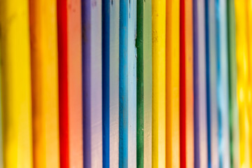 Obraz premium Part of wooden, rainbow colorful painted fence on a sunny hot summer day in a city park. Abstract multicolored background.