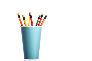 Bunch of multi colored wooden pencils with rubber eraser in blue disposable biodegradable paper cup isolated on white background. Recycling concept. Minimalism style. Copy space for advertisement - Powered by Adobe