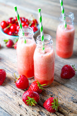 Red smoothie with strawberry on a wooden table