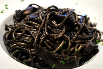 Delicious Italian black pasta with cuttlefish ink and fillet