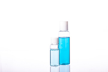 Obraz na płótnie Canvas set of small hand sanitizers for personal hygiene. two Personal sprayers for disinfection. Coronavirus Pandemic Control. Transparent and blue alcoholic disinfectant solution.