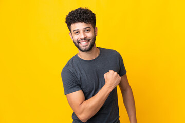 Young Moroccan man isolated on yellow background celebrating a victory