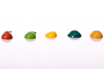 Color paints squeezed out of tubes on glass table surface. volumetric smears, large drops of glossy paint in different colors reflected in glass isolated on white background.