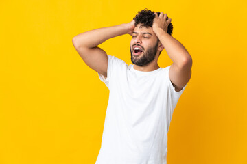 Fototapeta na wymiar Young Moroccan man isolated on yellow background stressed overwhelmed