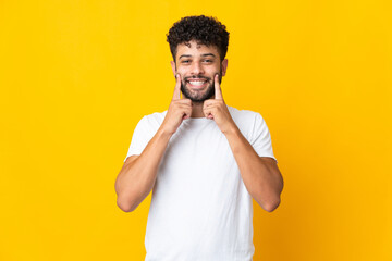 Young Moroccan man isolated on yellow background smiling with a happy and pleasant expression