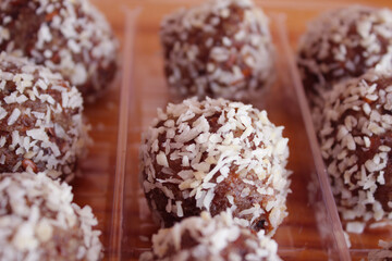 Handmade delicious sweets made from dried fruits, nuts and honey, sprinkled with coconut. Healthy sweets. Dessert.