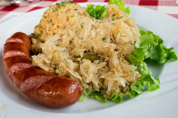 Traditional dish in Slovenia - kranjska klobasa (pork sausage) with mashed pe puree and stewed cabbage