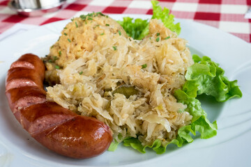 Traditional dish in Slovenia - kranjska klobasa (pork sausage) with mashed pe puree and stewed cabbage