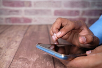 Close up of young man hand using smart phone.
