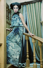 woman in elegant dress posing on stairs