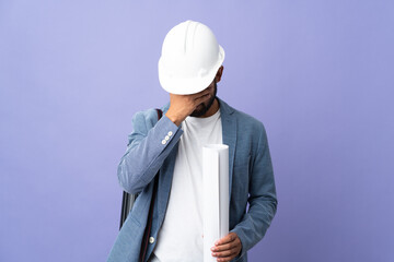 Young architect Moroccan man with helmet and holding blueprints over isolated background with tired and sick expression