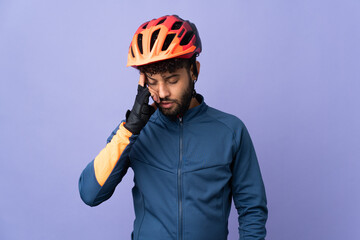 Young Moroccan cyclist man isolated on purple background with headache