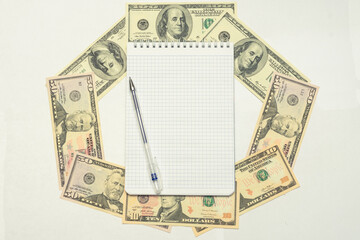 Dollars USA, pen and notebook, top view, copy space