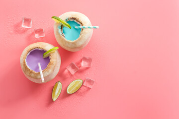 Fresh fruit drink in coconut with straw, top view