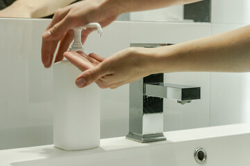 Modern bathroom with sink and soap/disinfection fluid (mock-up). Cleaning hands in washbasin.
