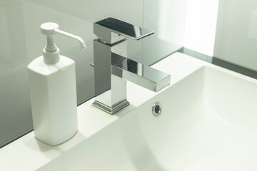 Modern bathroom with sink and soap/disinfection fluid (mock-up). Cleaning hands in washbasin.