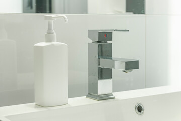 Modern bathroom with sink and soap/disinfection fluid (mock-up). Cleaning hands in washbasin.