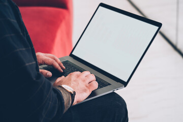 Unrecognizable man typing on laptop keyboard
