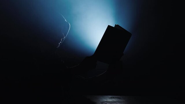 The believer reads the holy book, from it comes the lui of light