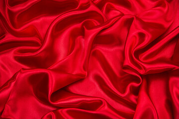 Background of draped red silk fabric. Creases and creases in the fabric. Concept of new year, Christmas, Valentine's day.