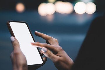Woman using phone in evening city