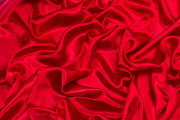 Background of draped red silk fabric. Creases and creases in the fabric. Concept of new year,...