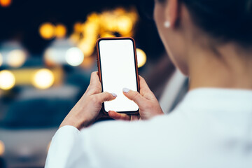 Crop faceless woman taking photo on smartphone in street