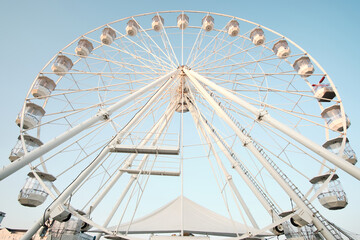 Low angle view of a ferris wheel against a  clear blue sky