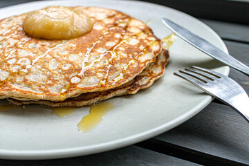 Pancakes with apple sauce and honey. Breakfast table with pancakes and coffee. 