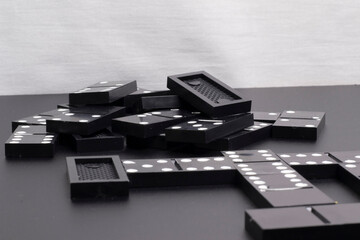 The black dominoes were laid out on a dark table.