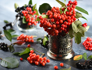 Beautiful bouquet of viburnum red and black mountain ash in a glass