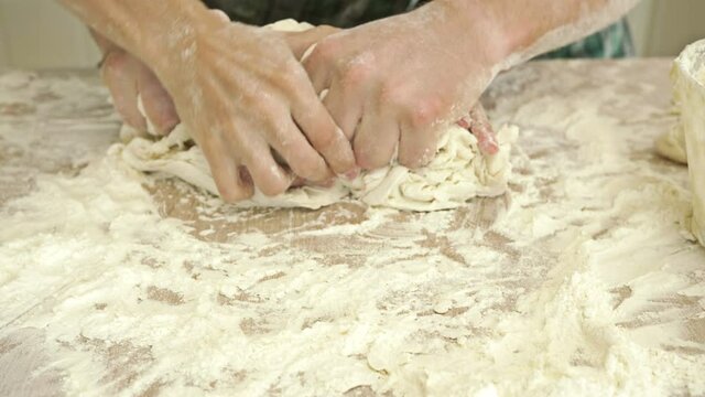 Male and female hands knead the dough together. Close-up. Mutual relationship.
