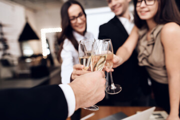 People sit together and clink glasses of champagne